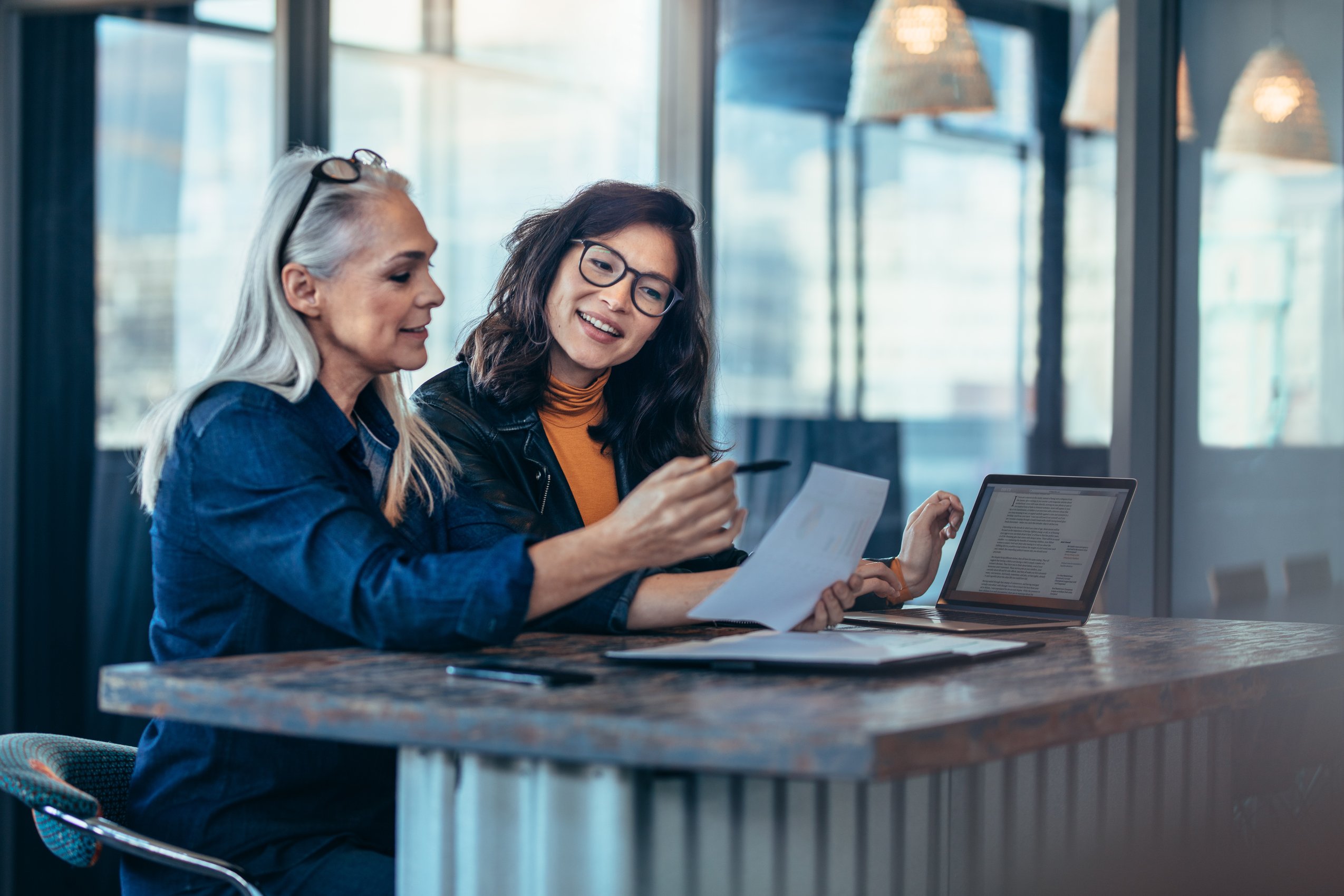 Two women analyzing document