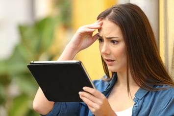 Woman looking at tablet worried